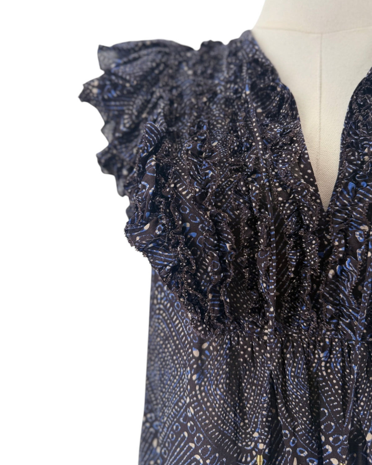 Short sleeve mulberry diamond print, tiered ruffle sleeves, smocked detailing along the split v-neckline, drawstring tassel accent on a mannequin on a white background