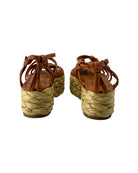 Pair of brown sandals with woven grass sole on a white background