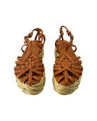 Pair of brown woven sandals with straw sole on a white background