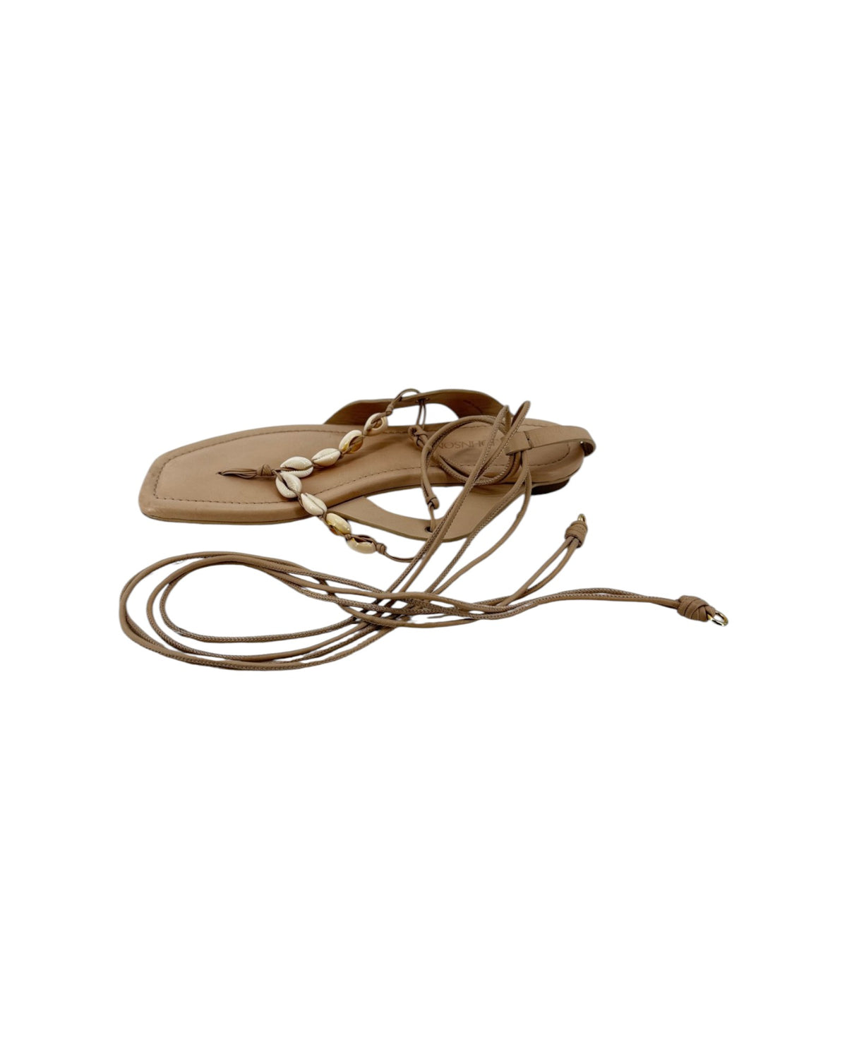 Leather thong sandal with long leather ankle wrap straps and seashell details on a white background