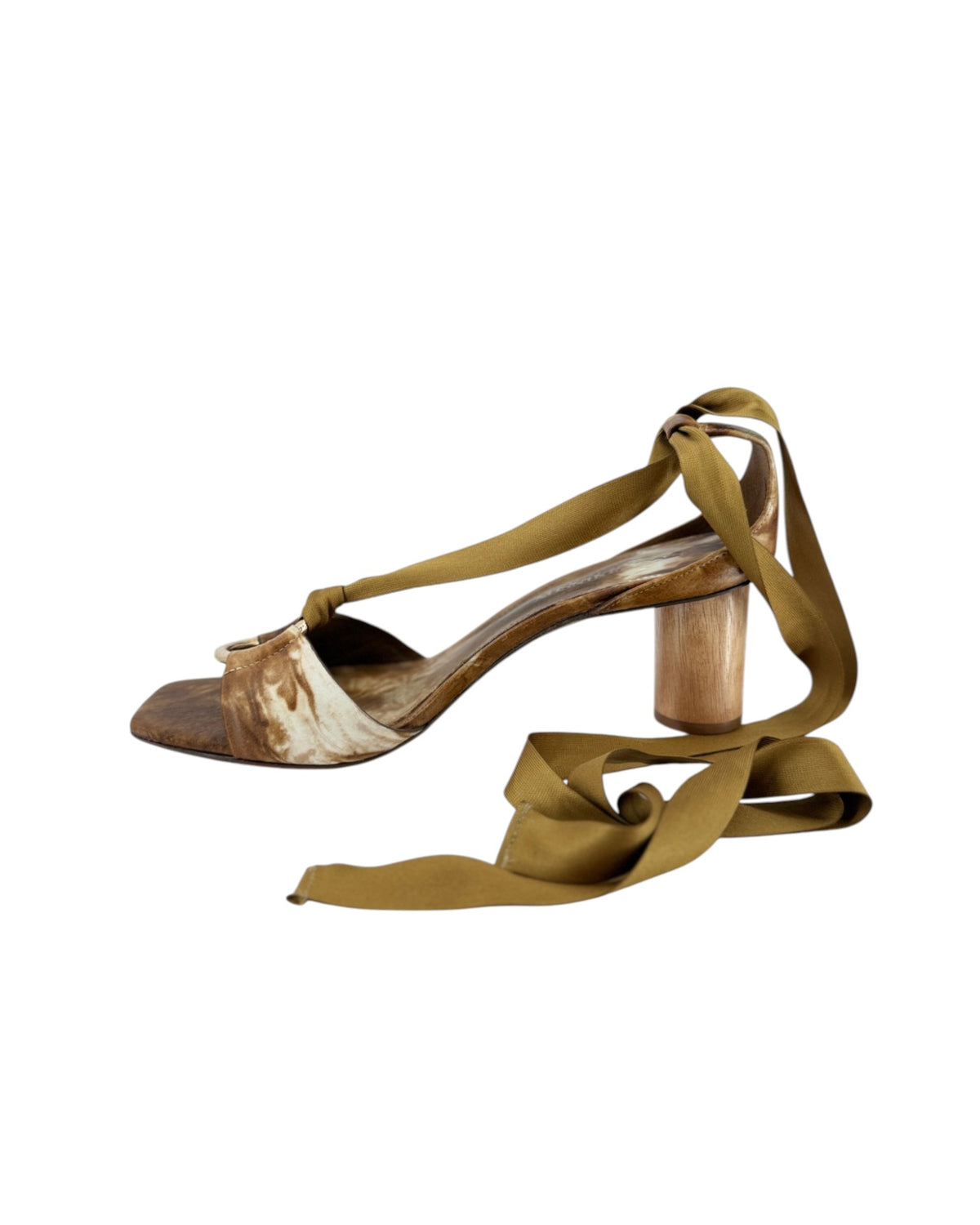 Brown and white heels with a gold ring at the toe strap heels and satin ribbon laces on a white background