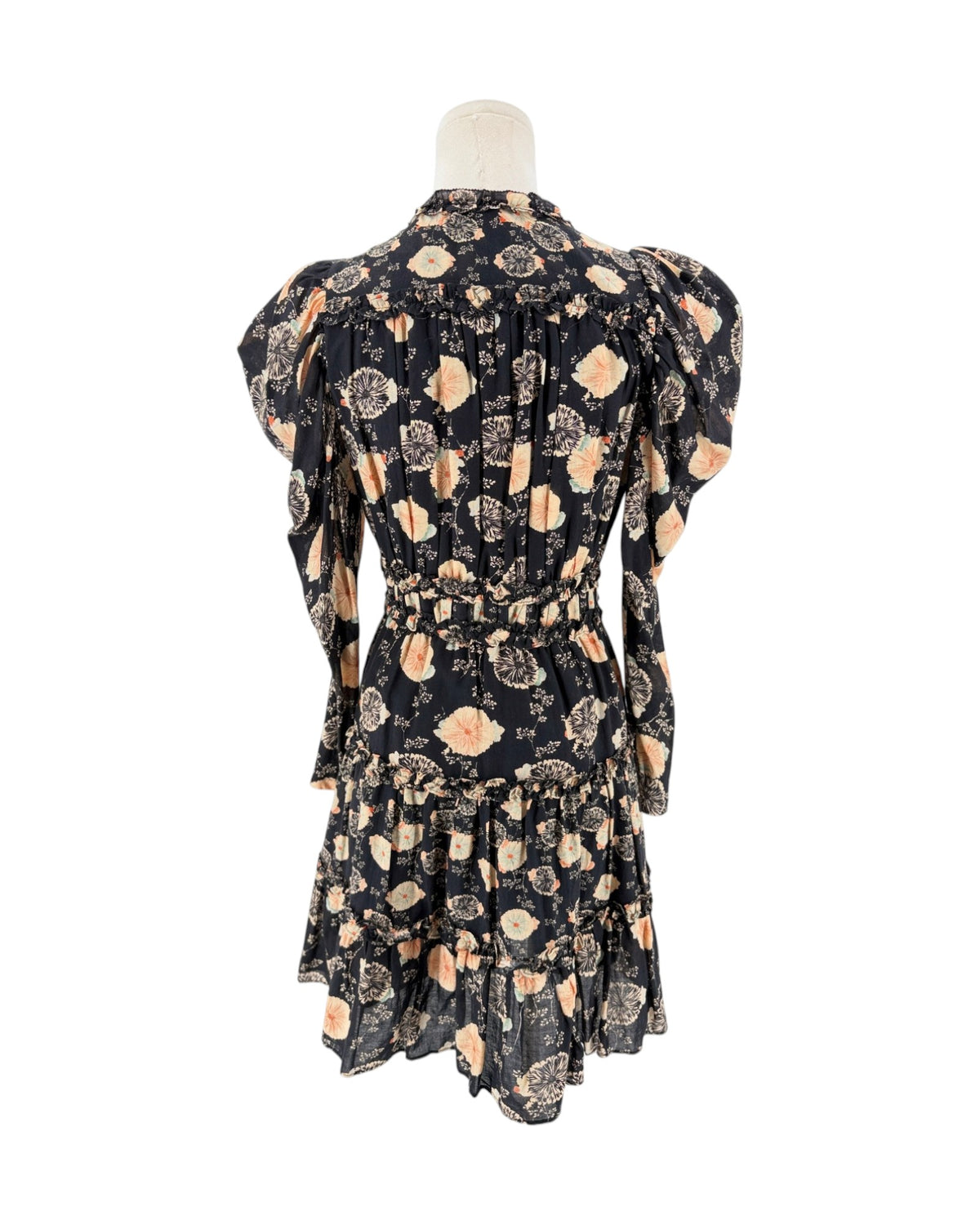 A black long-sleeve mini dress with a beige and peach floral pattern, displayed on a cream mannequin torso against a plain white background.