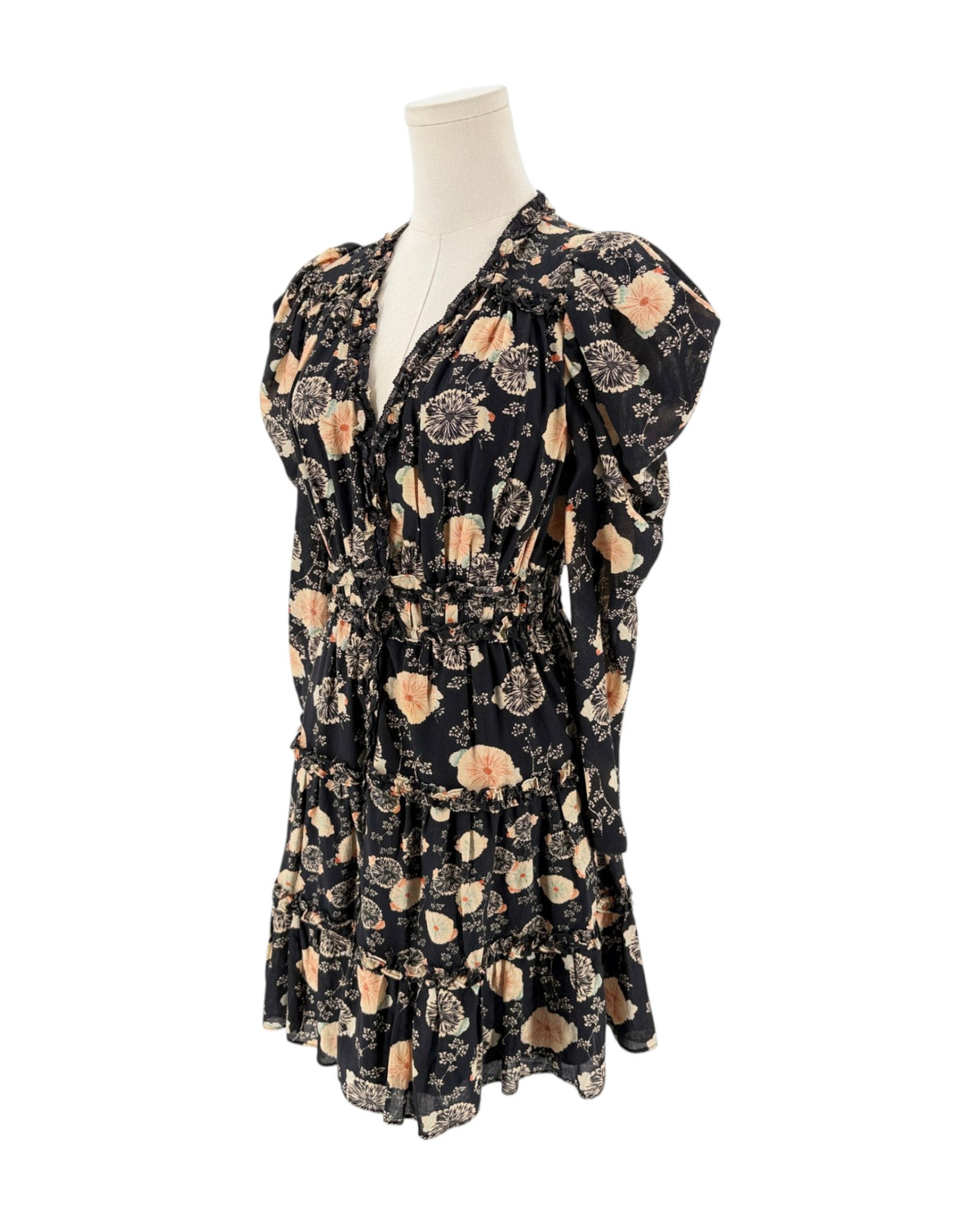 A black long-sleeve mini dress with a beige and peach floral pattern, displayed on a cream mannequin torso against a plain white background.