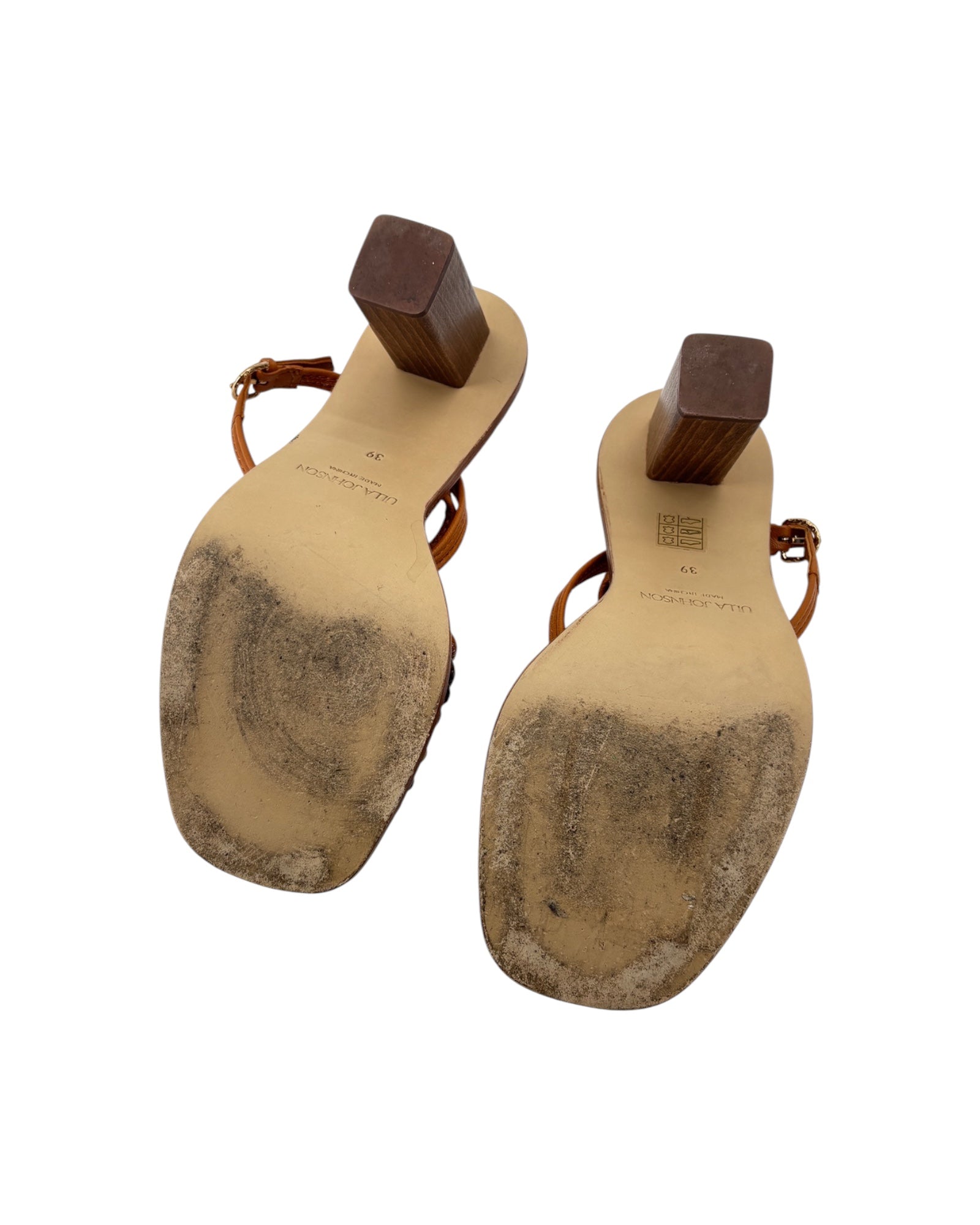 Pair of sandals with tan soles on a white background