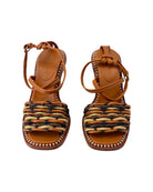 Pair of brown sandals with woven design on a white background