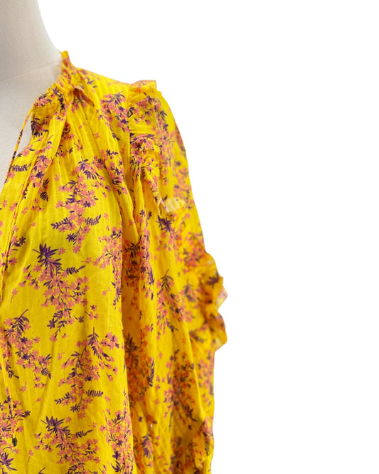 Yellow floral dress on a mannequin against a white background