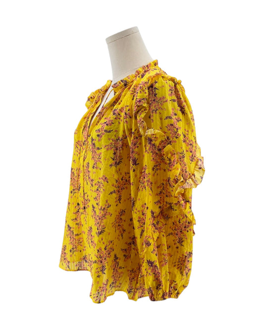 Yellow floral blouse on a mannequin against a white background