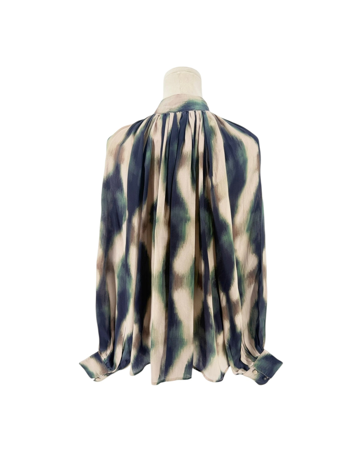 A close-up of a high-neck blouse displayed on a mannequin. The fabric has an abstract, painterly pattern in beige, navy blue, and sage green.
