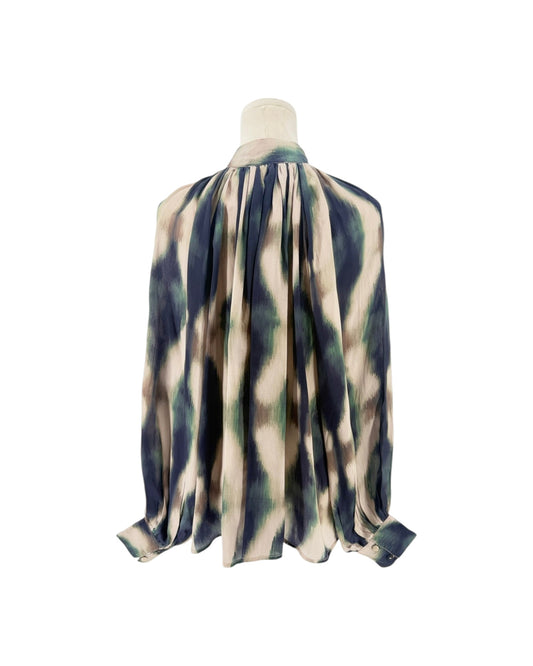 A close-up of a high-neck blouse displayed on a mannequin. The fabric has an abstract, painterly pattern in beige, navy blue, and sage green.