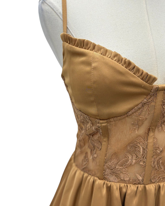 Gold dress with intricate patterns on a mannequin against a white background