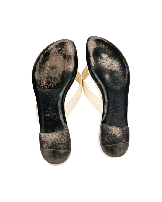 Black sandal soles with visible wear on a white background
