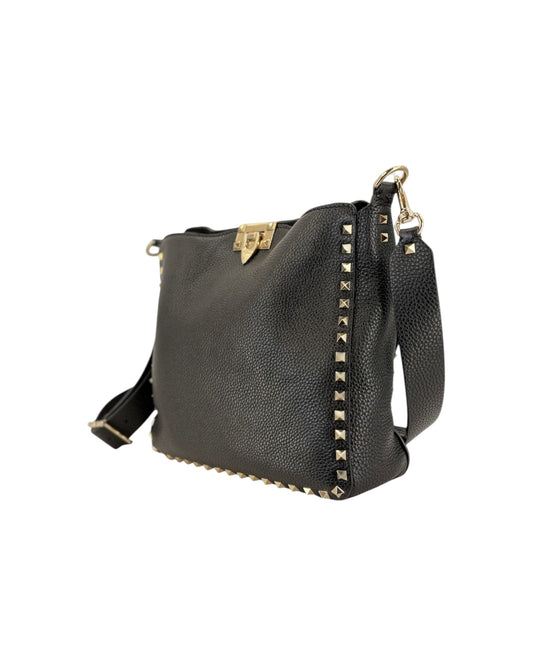 Black leather handbag with gold studs on a white background