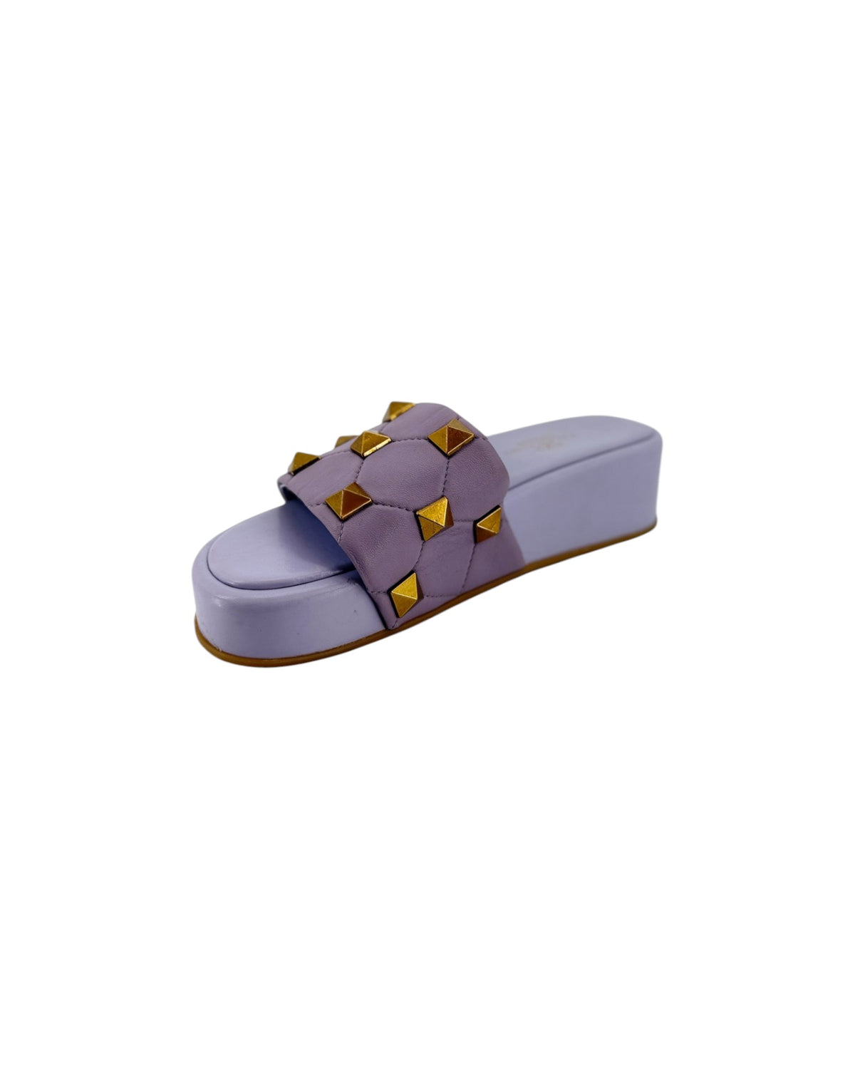 A pair of lavender slide sandals featuring a wide strap embellished with gold pyramid studs, shown from a top-down view on a white background.