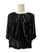 Black sequin top on a mannequin against a white background