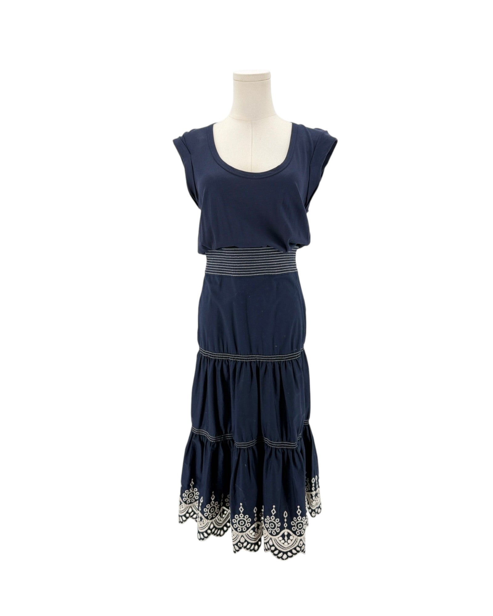 Navy sleeveless midi dress with delicate trim along the hem, scoop neck, side zip and hook. On a mannequin on a white background.