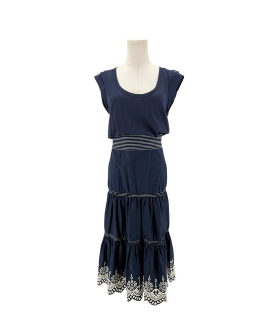 Navy sleeveless midi dress with delicate trim along the hem, scoop neck, side zip and hook. On a mannequin on a white background.