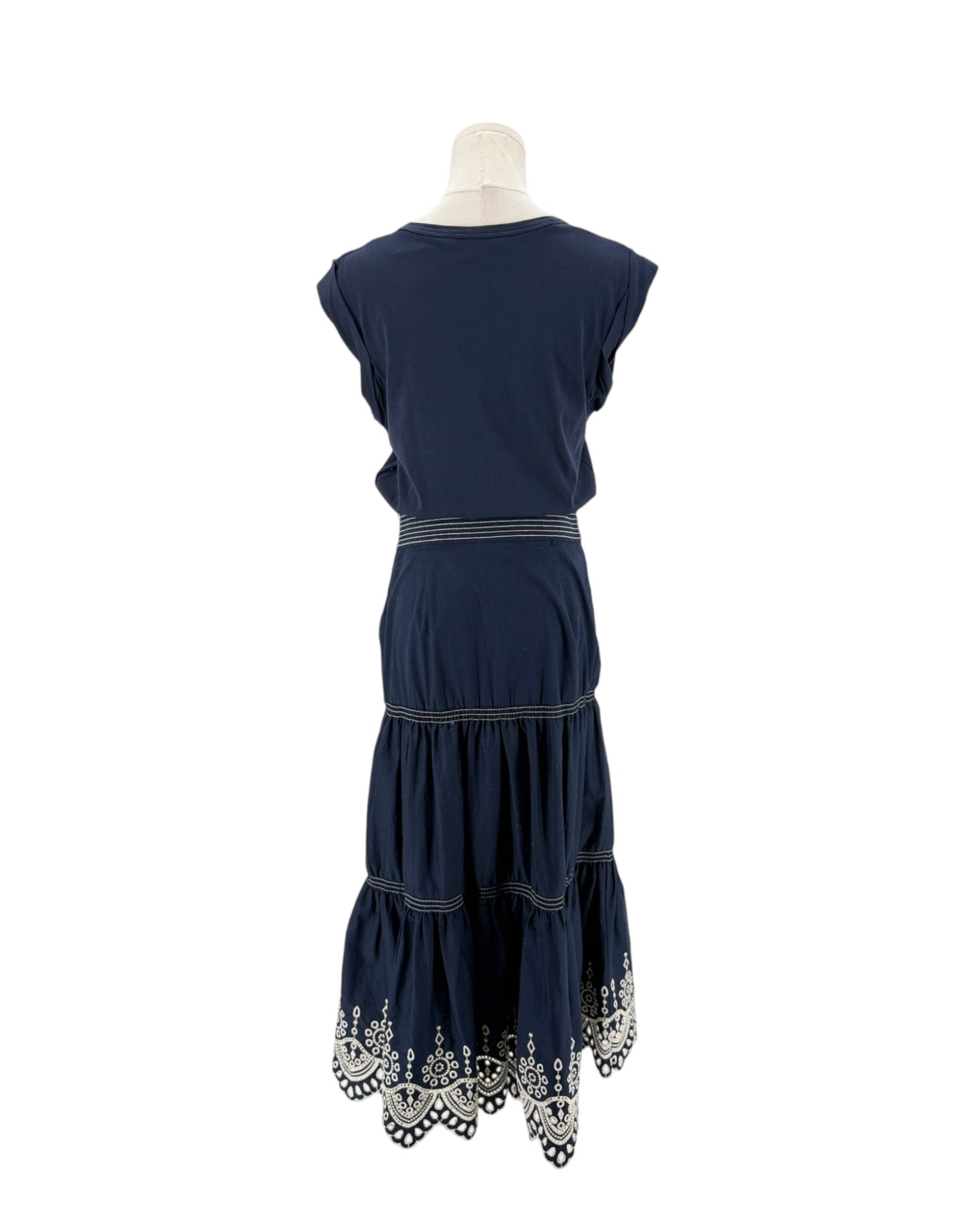 Navy sleeveless midi dress with delicate trim along the hem, scoop neck, side zip and hook. On a mannequin on a white background.