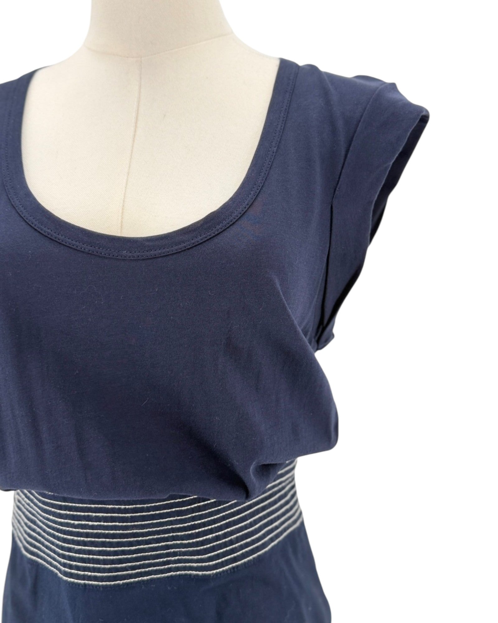 Navy sleeveless midi dress with delicate trim along the hem, scoop neck, side zip and hook. On a mannequin on a white background.