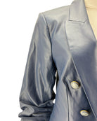 Close-up of a navy blazer with button details on a white background