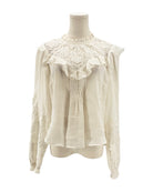 White blouse with lace details on a mannequin against a white background