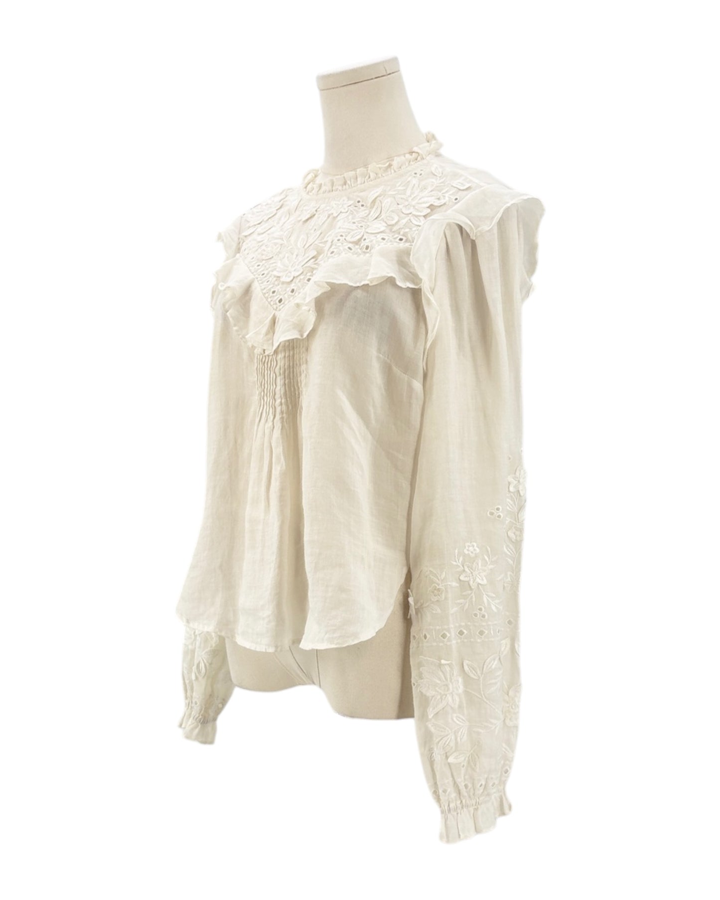 White lace blouse on a mannequin against a white background