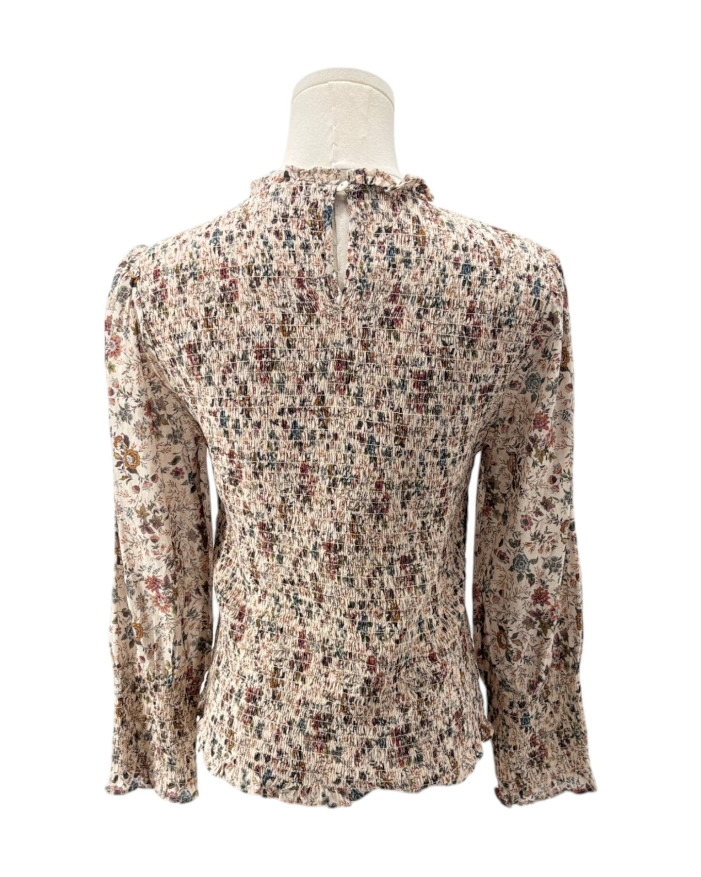 Floral patterned blouse on a mannequin against a white background