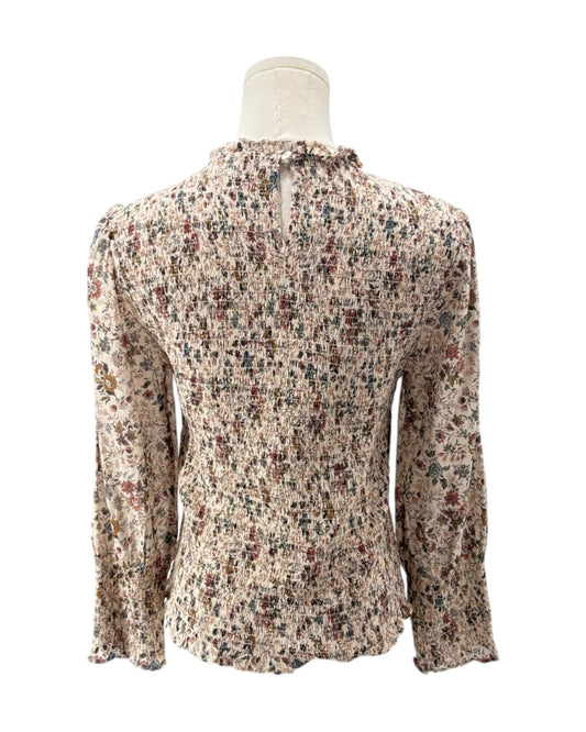 Floral patterned blouse on a mannequin against a white background