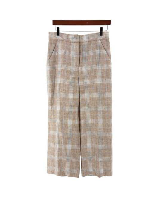 A pair of beige and white plaid cropped trousers hanging from a wooden hanger against a plain white background.