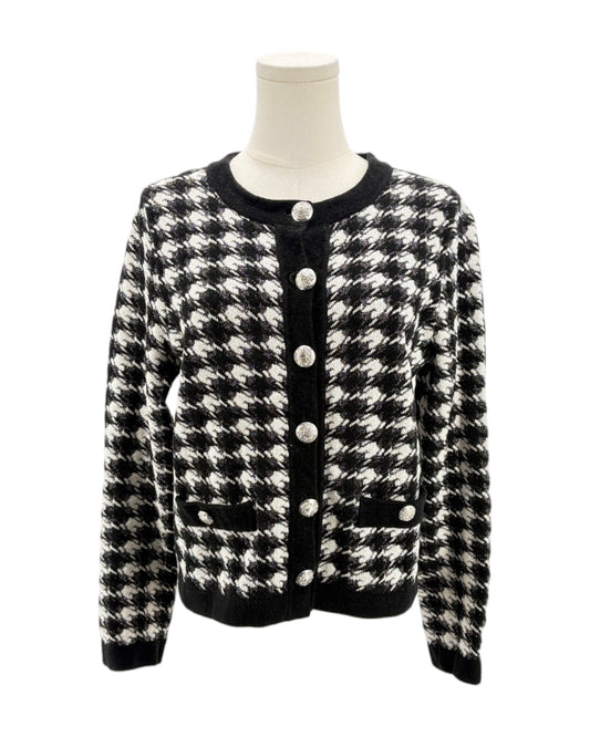 Black and white houndstooth patterned cardigan on a mannequin against a white background