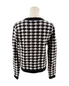 Black and white checkered sweater on a mannequin against a white background