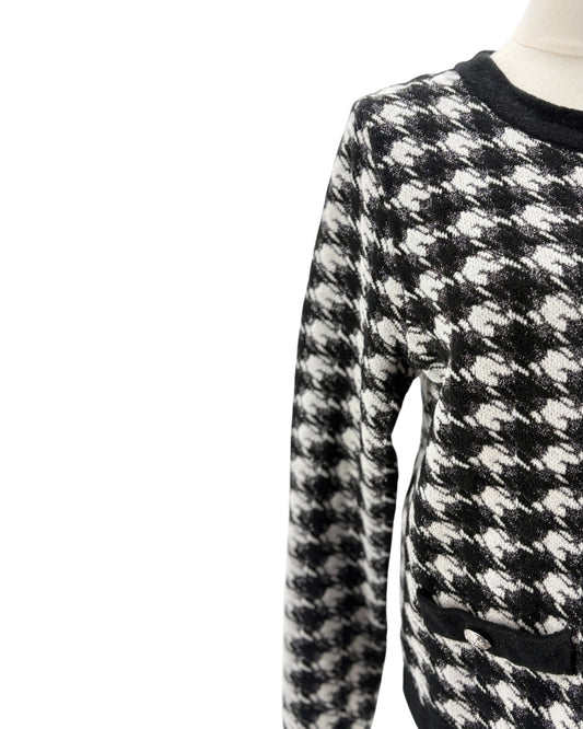 Black and white checkered sweater on a mannequin against a white background