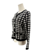 Black and white checkered cardigan on a mannequin against a white background