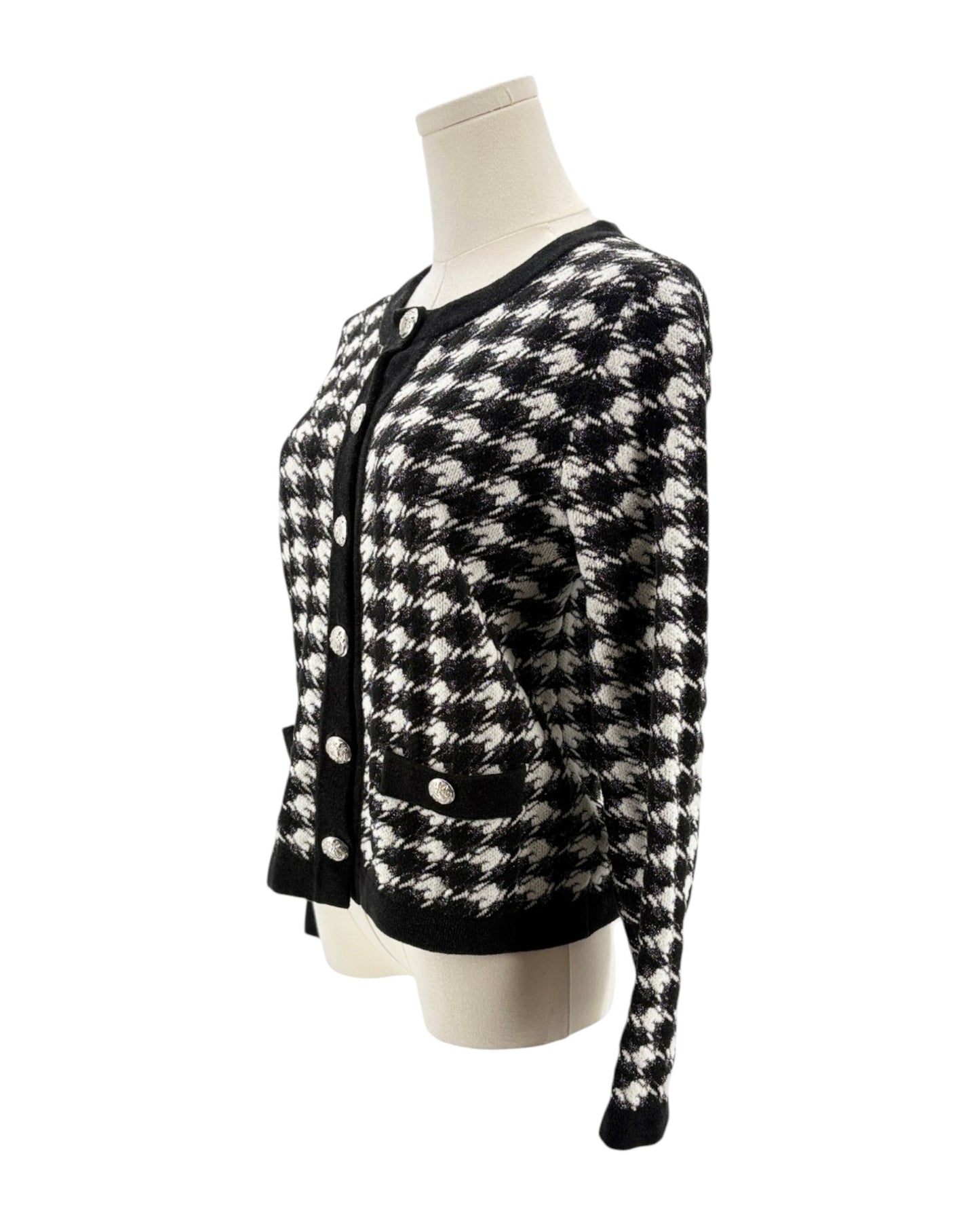 Black and white checkered cardigan on a mannequin against a white background