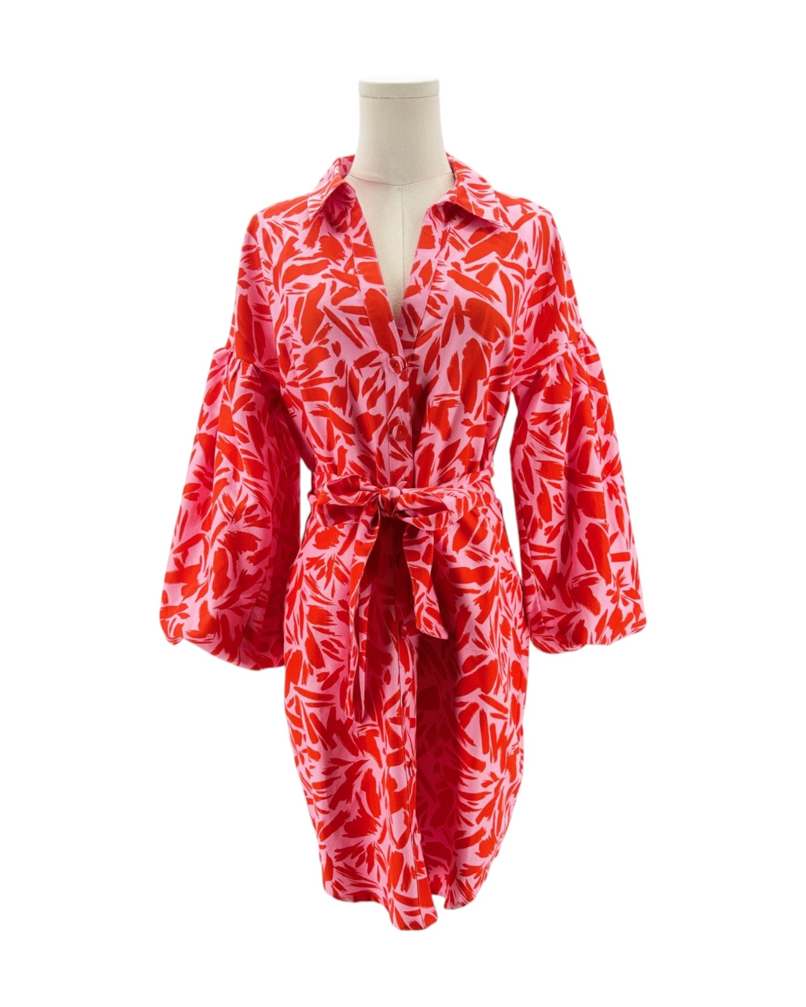 Red and white patterned dress on a mannequin against a white background