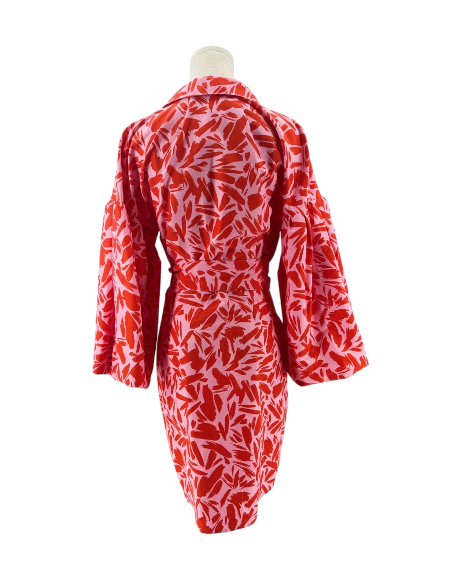 Red and white patterned dress on a mannequin against a white background