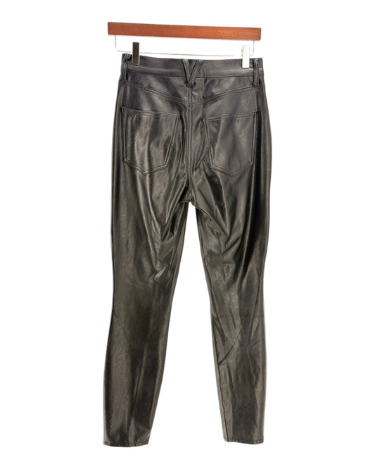 Black leather pants on a hanger against a white background