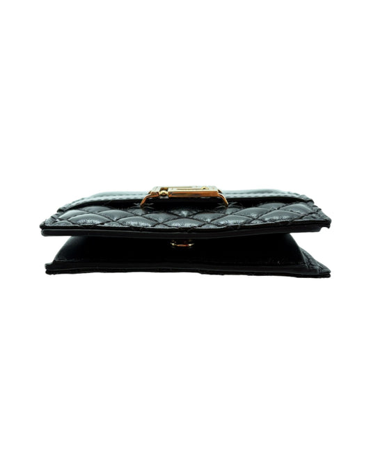 Black quilted wallet with gold clasp on a white background