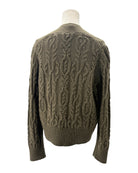 Green cable knit sweater on a mannequin against a white background