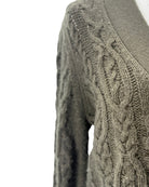 Close-up of a cable knit sweater on a white background