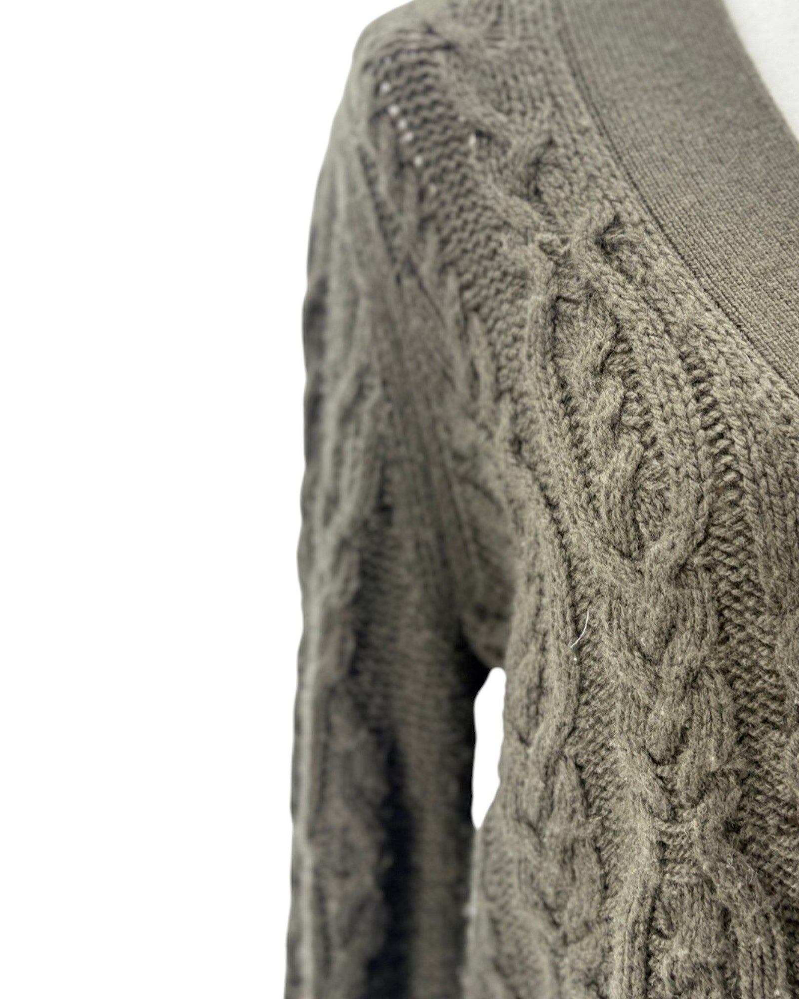 Close-up of a cable knit sweater on a white background