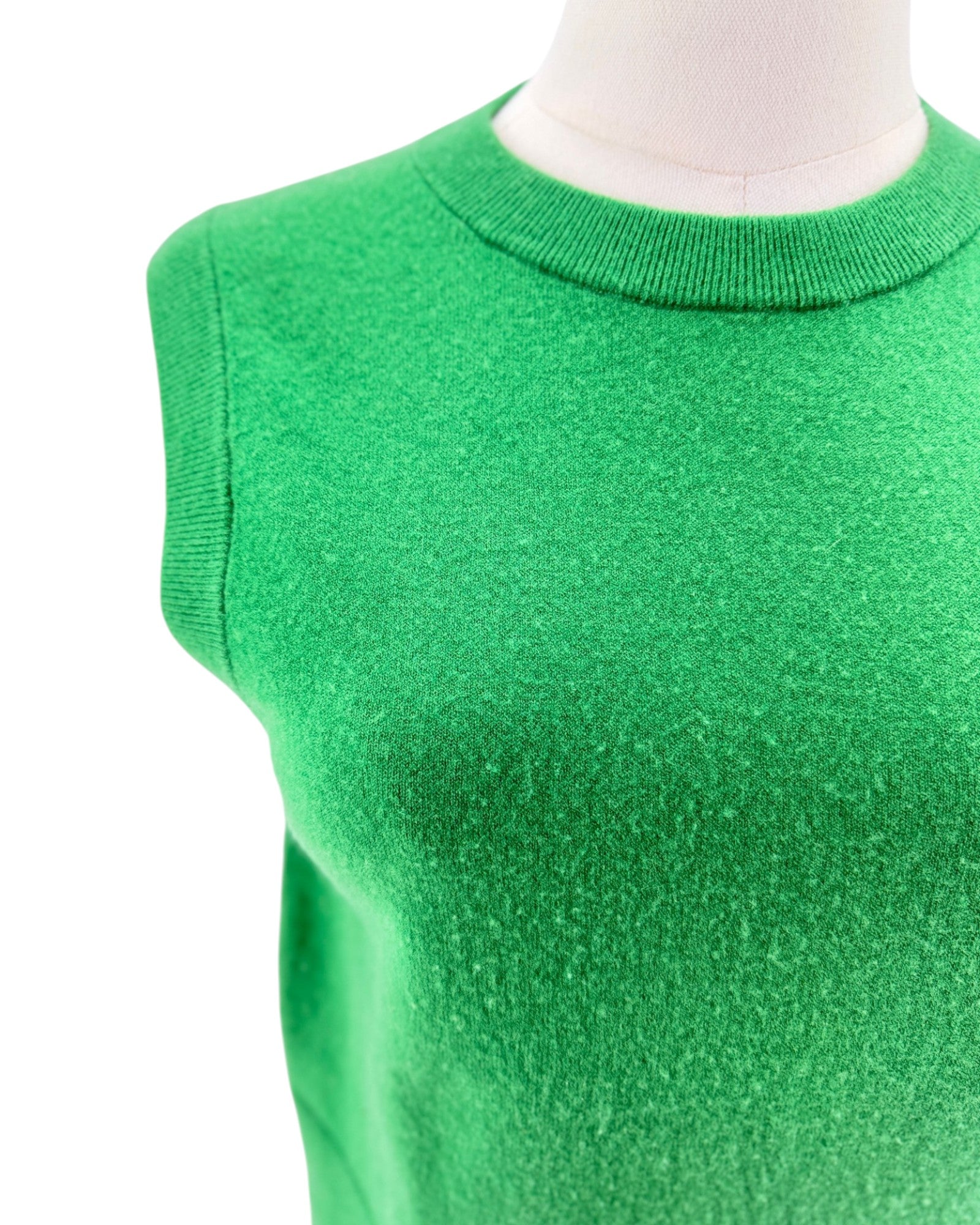 A bright green sleeveless knit sweater displayed on a mannequin torso against a plain white background.