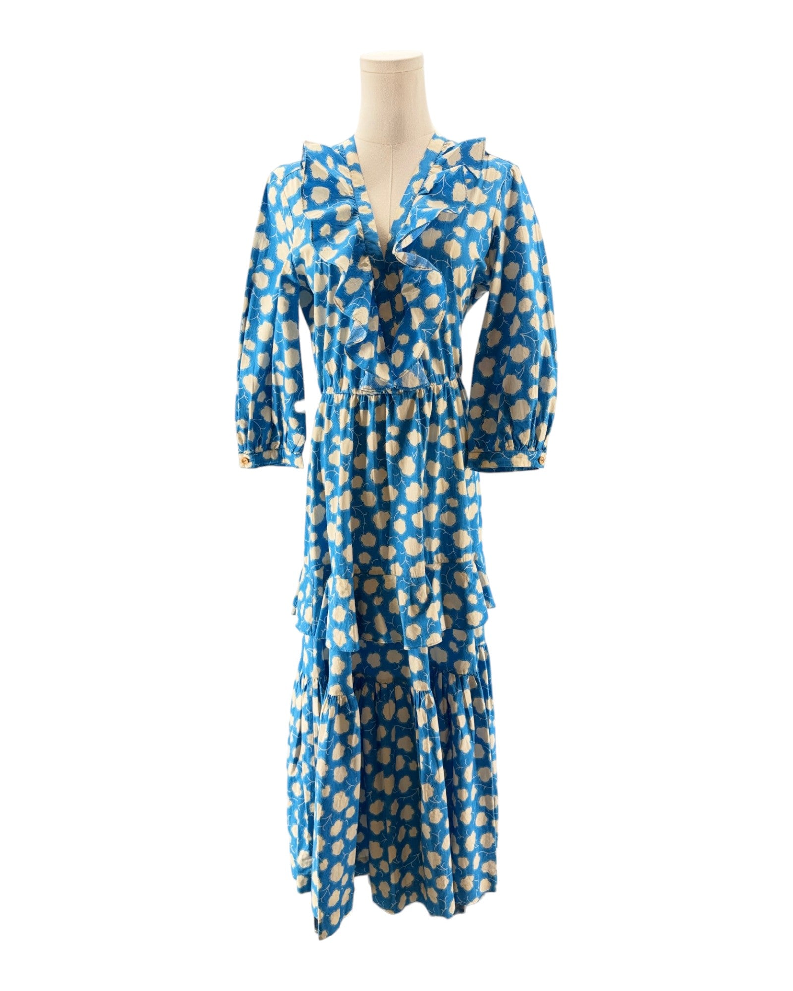 Blue dress with yellow floral pattern on a mannequin against a white background