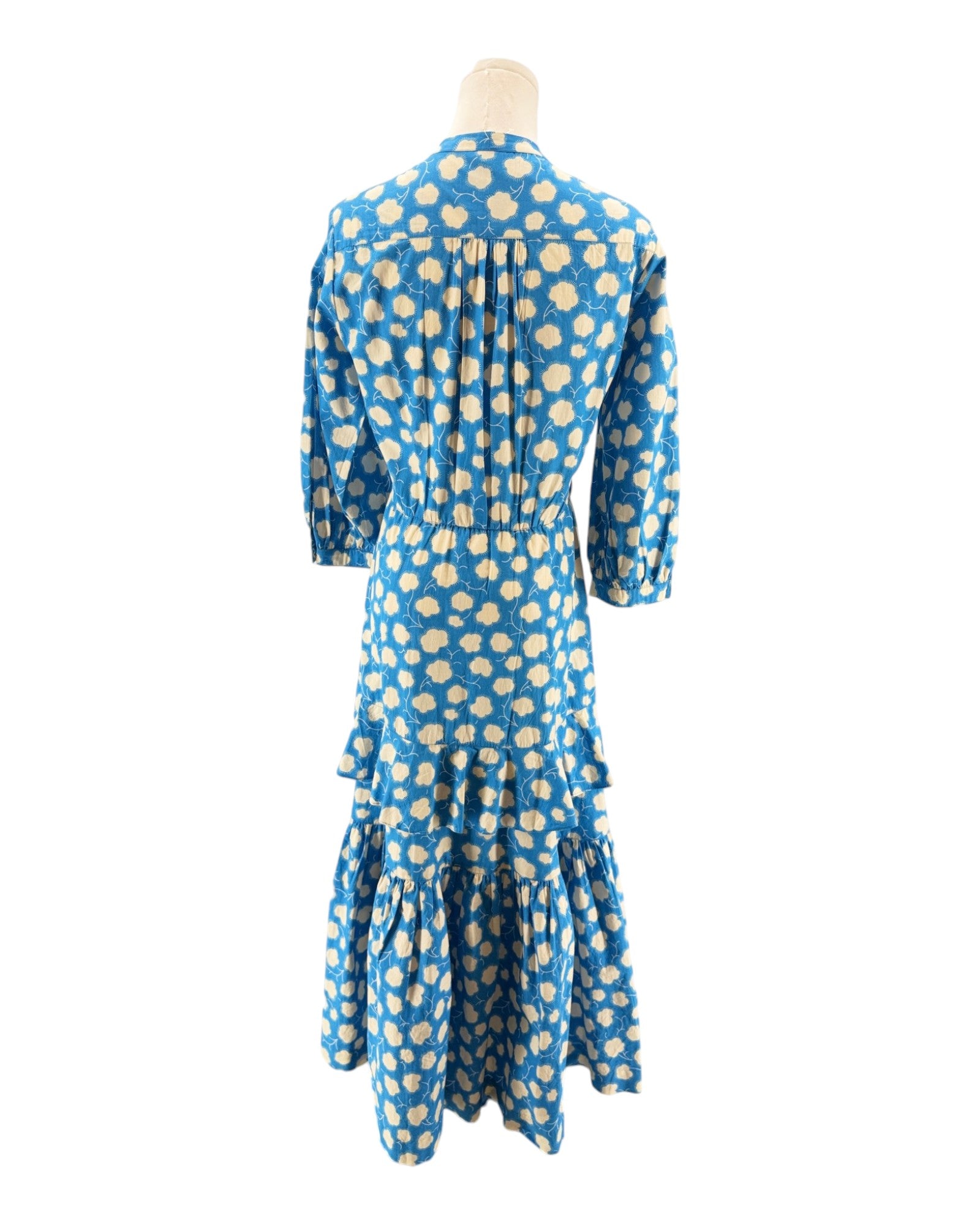 Blue dress with white polka dots on a mannequin against a white background