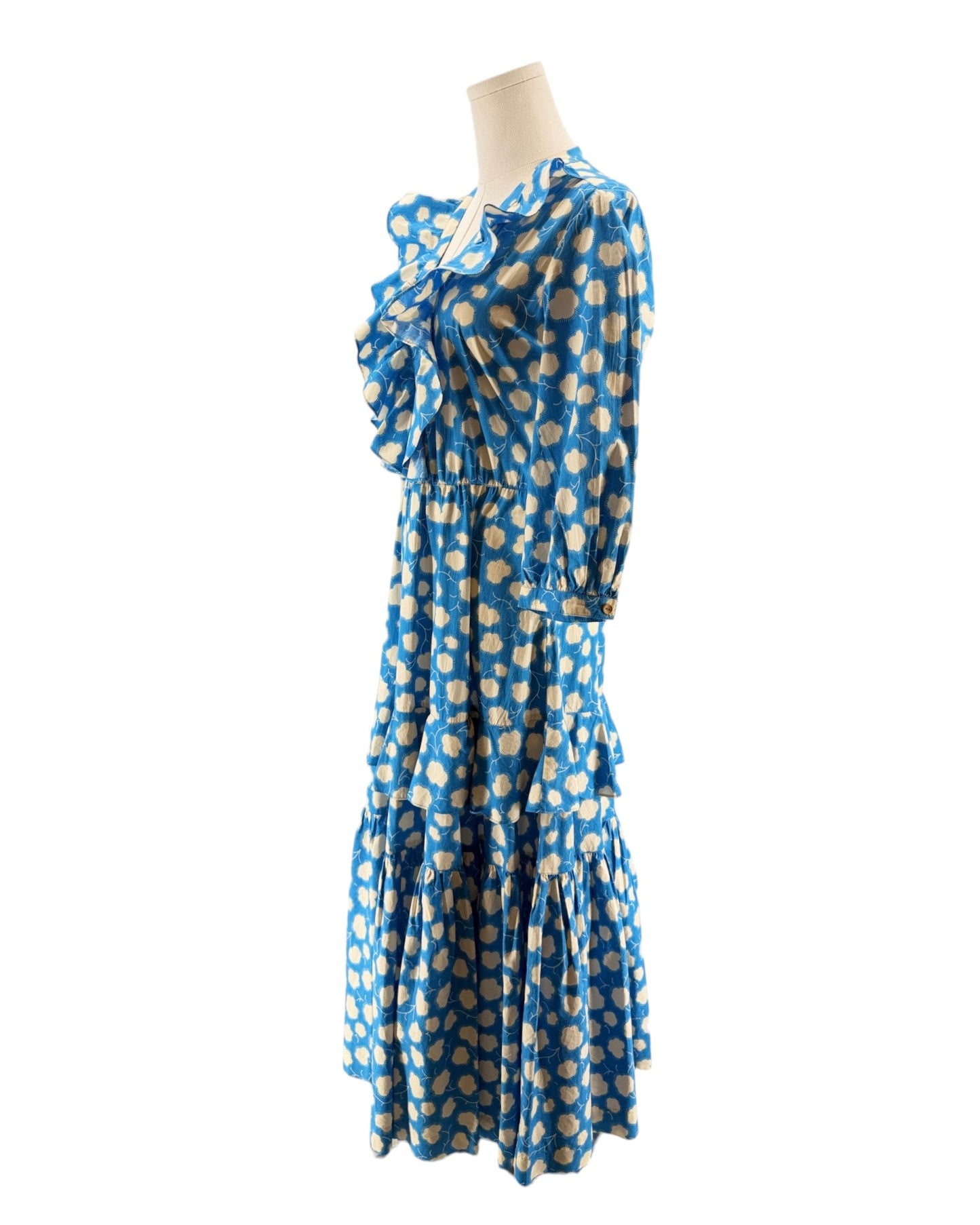 Blue dress with gold polka dots on a mannequin against a white background