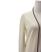Cream cardigan with black trim on a mannequin against a white background