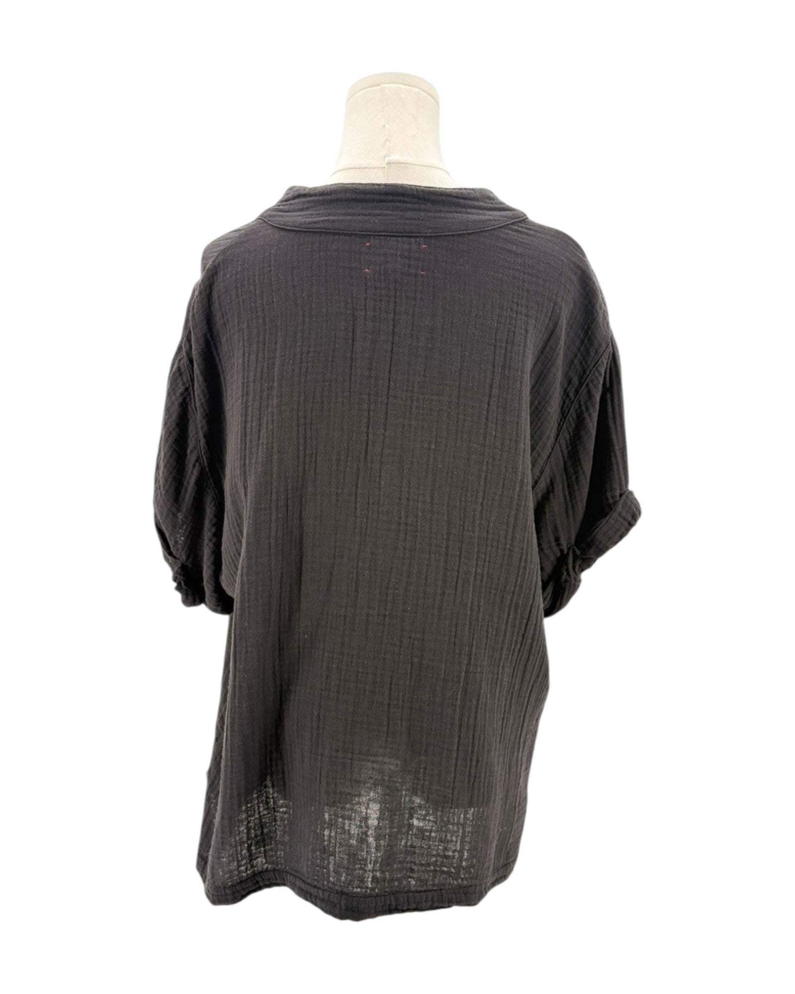 black textured blouse on a mannequin against a white background