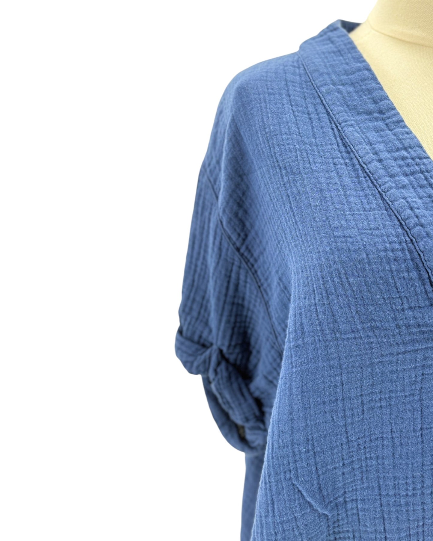 Blue textured garment on a mannequin against a white background