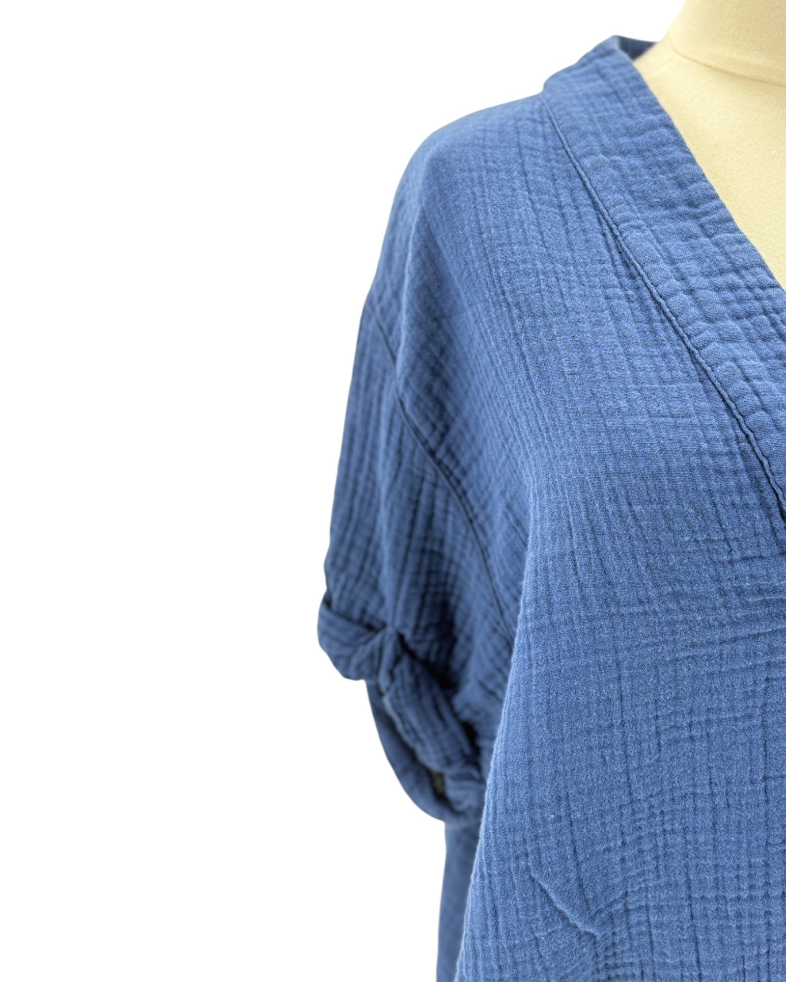 Blue textured garment on a mannequin against a white background