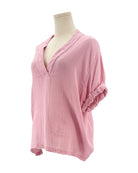 Pink textured blouse on a mannequin against a white background