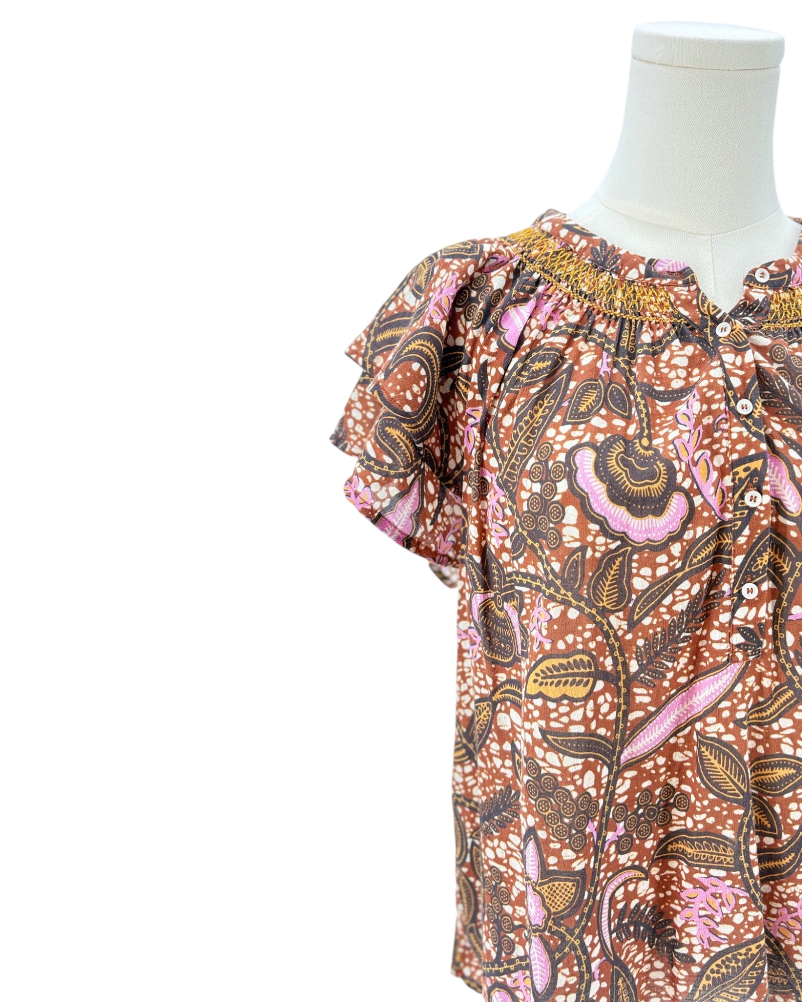 Xirena floral patterned blouse on a mannequin against a white background